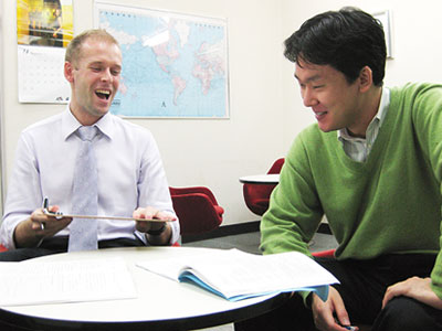 トーク・アベニューの英会話レッスン風景写真。外国人講師と生徒がマンツーマンで楽しそうにレッスンしている様子